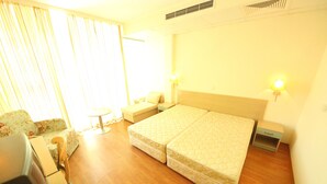 Ein Hotelzimmer mit Doppelbett, Nachttisch, Sessel und einer kleinen Couch.