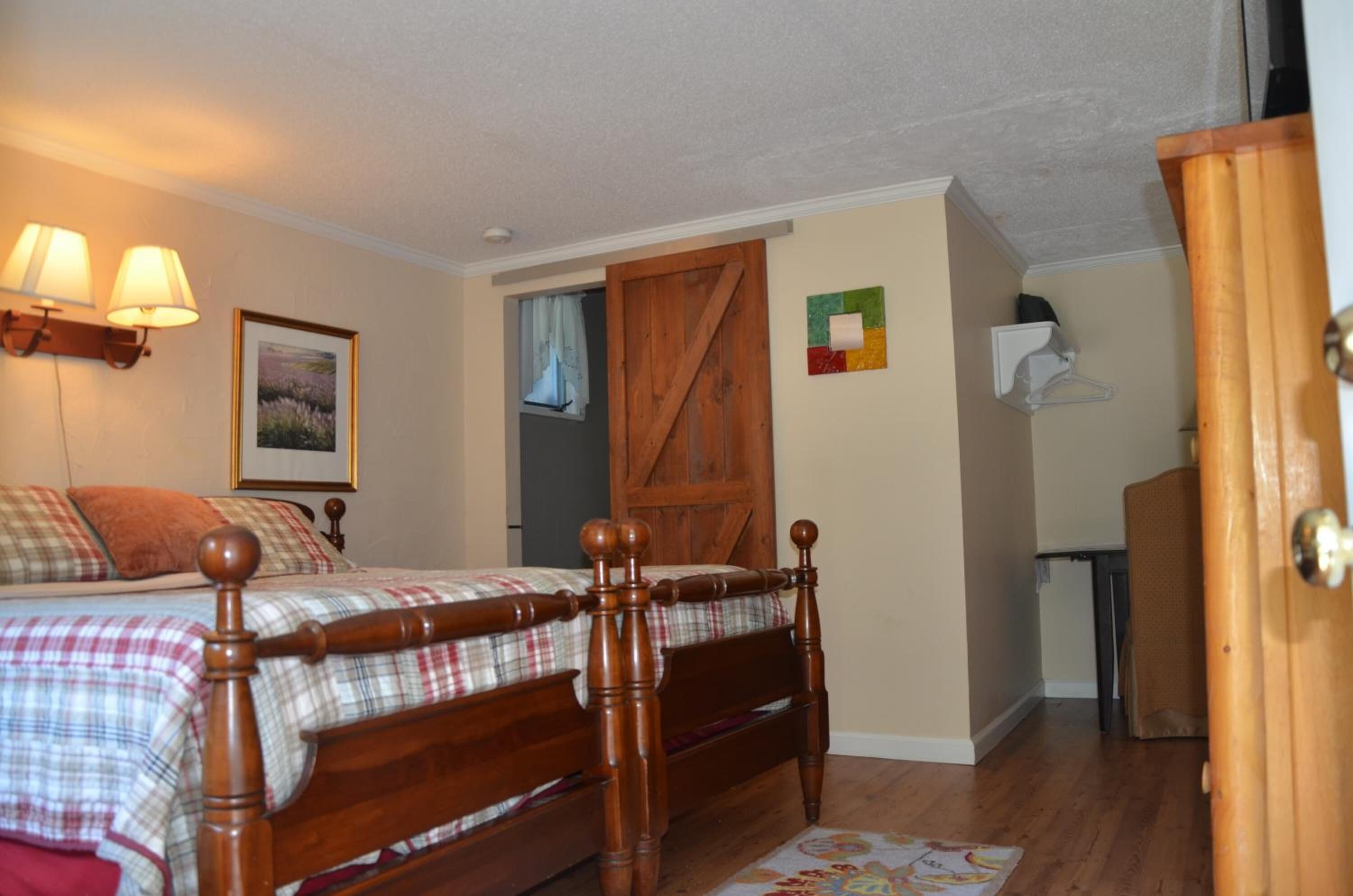 A bedroom with a wooden bed, a small desk, and a wardrobe.