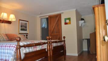 A bedroom with a wooden bed, a small desk, and a wardrobe.