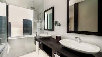 A modern bathroom with a glass-enclosed shower, two sinks, and a large mirror.