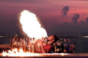 Enjoy live fire-breathing performances at the bar, surrounded by a selection of drinks.