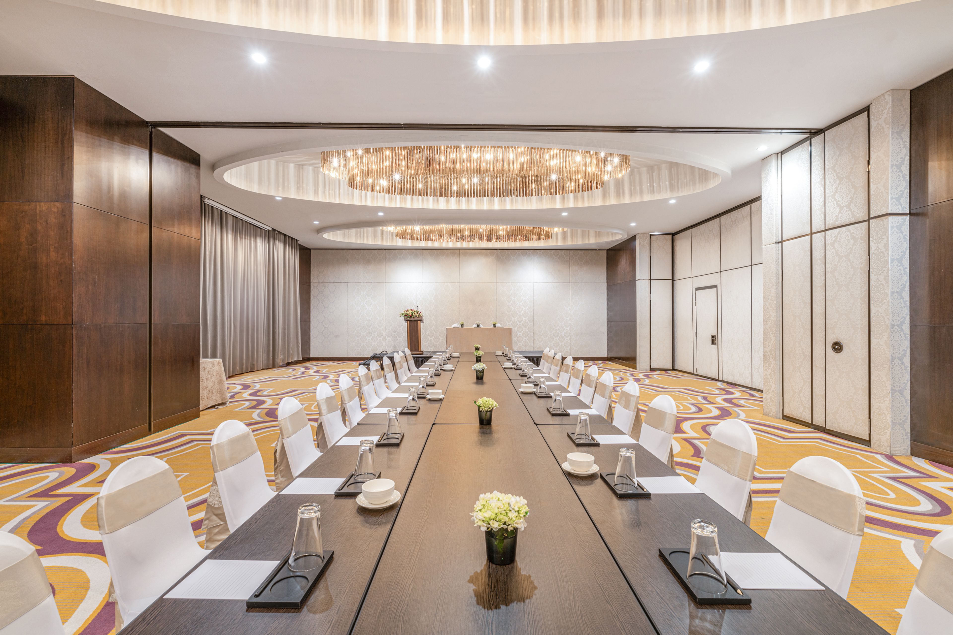 A conference room with a long table, chairs, and a chandelier.