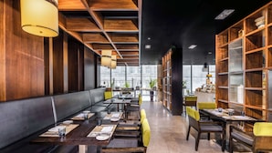 Un restaurant doté d’un long comptoir, de banquettes et d’étagères en bois.
