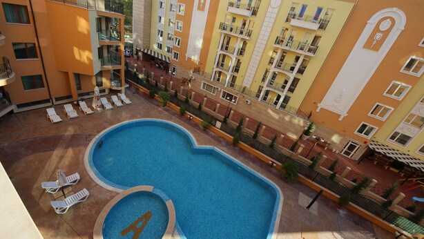 A hotel with a swimming pool, multiple balconies, and outdoor seating areas. - Menada Amadeus 3 Apartments (Sunny Beach)