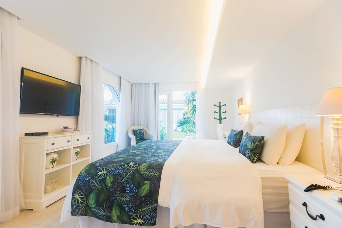 Une chambre d’hôtel avec un lit, une télévision, un bureau et une chaise.