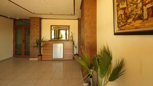 A lobby with a reception desk, a large mirror, and a painting on the wall. - Menada Amadeusz 1 Apartments (Sunny Beach)