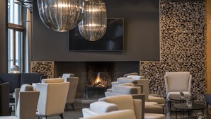 Ein stilvoller Lounge-Bereich mit Sofas, einem Kamin und einem großen Fernsehbildschirm.