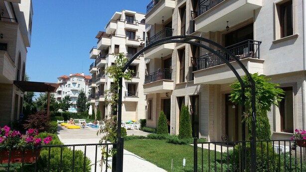 A residential building with multiple balconies, a gated entrance, and a well-maintained garden. - Menada Amara Apartments (Sunny Beach)