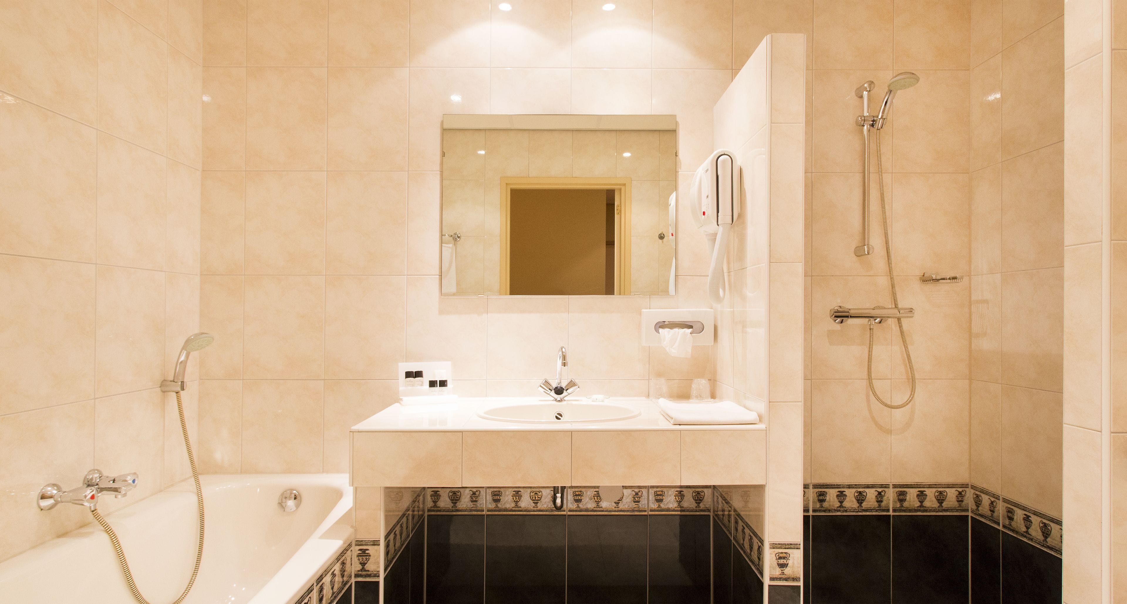 A bathroom with a bathtub, a sink, a mirror, and a shower.