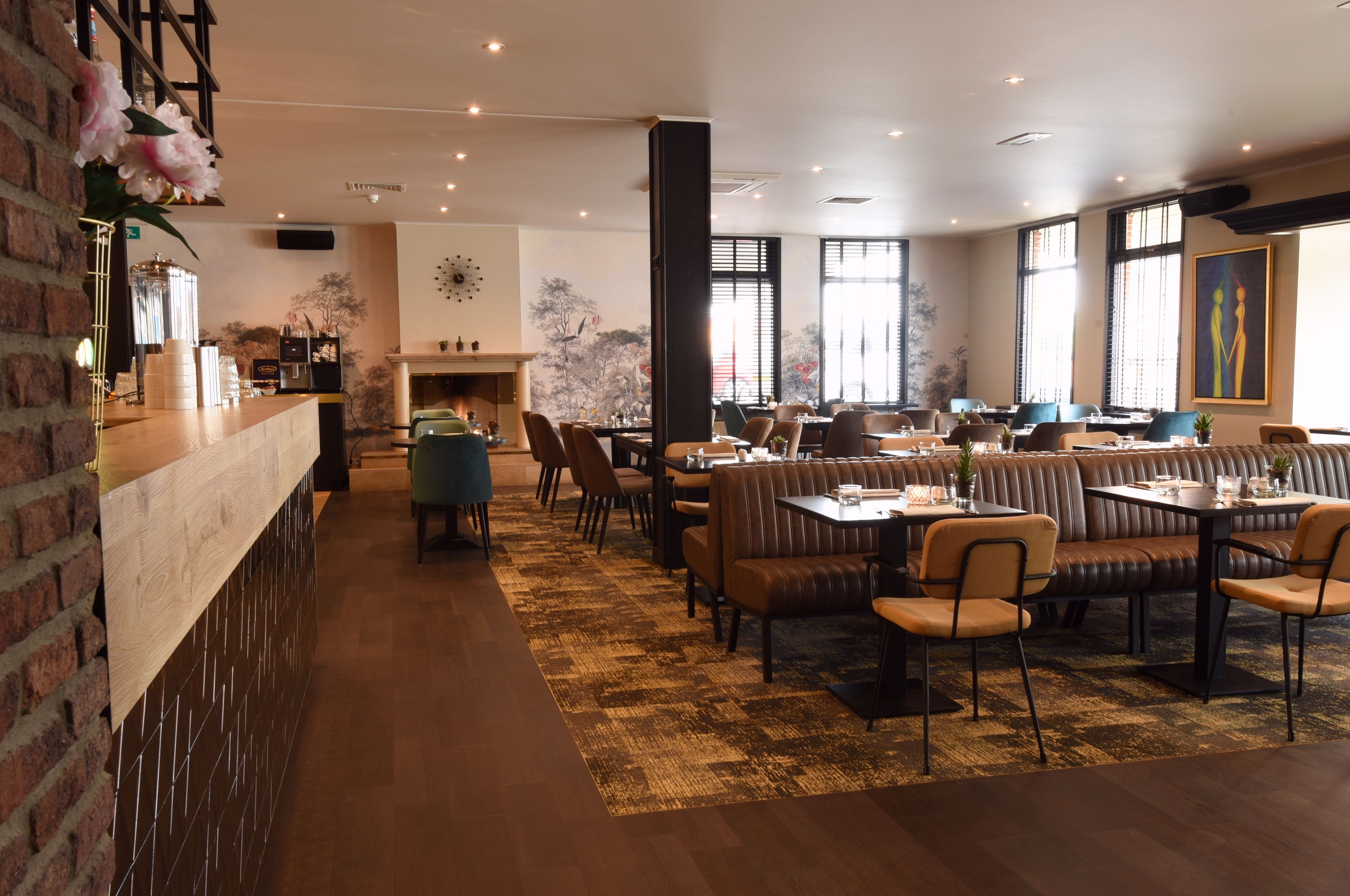 A restaurant with a brick wall, a bar area, and a seating arrangement including booths and tables.