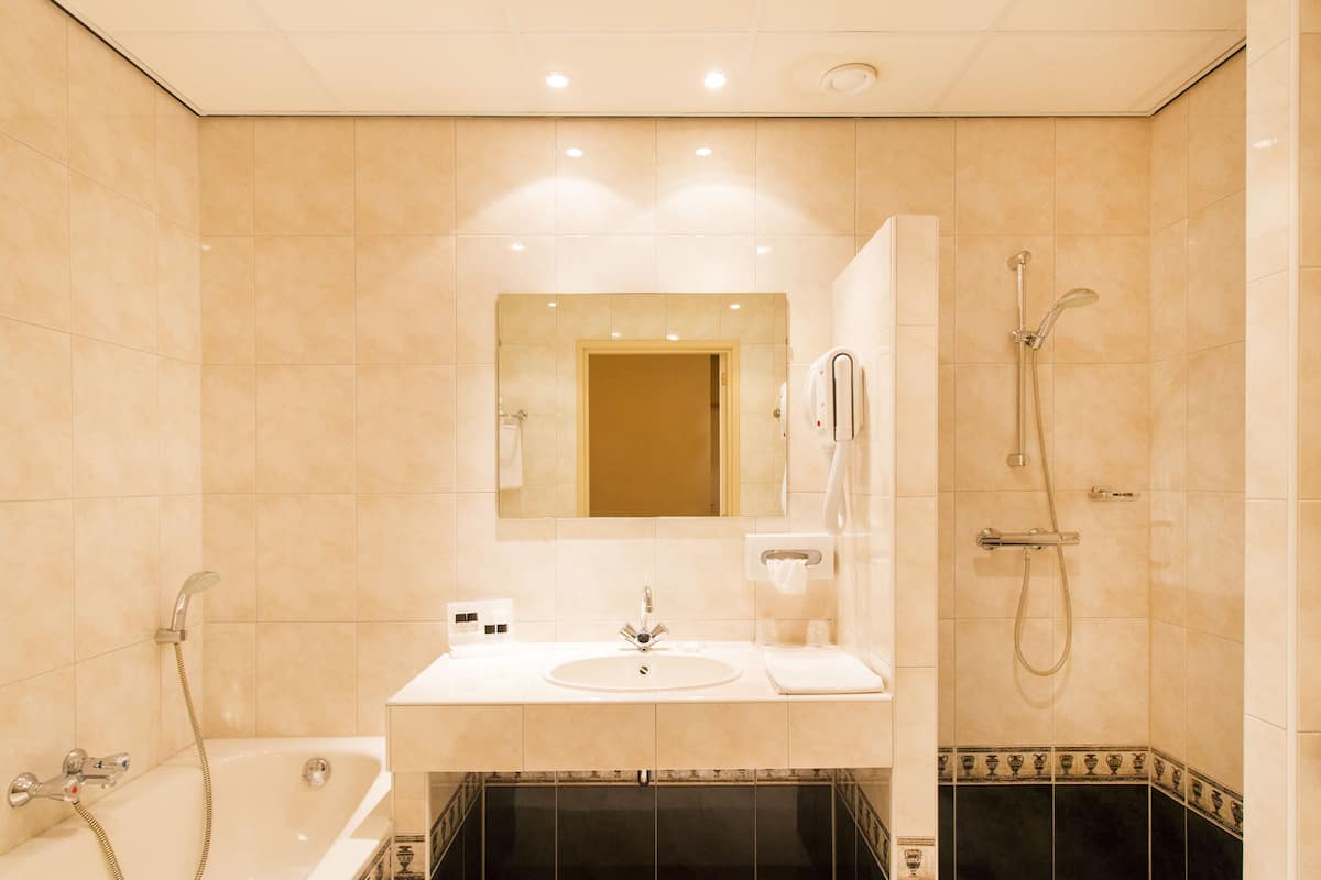 A modern bathroom with a bathtub, a sink, and a shower.