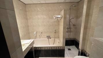 Une salle de bain avec une baignoire, une douche et des toilettes.