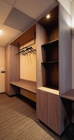 A room with a built-in bench, wooden shelving, and a hanging rack.
