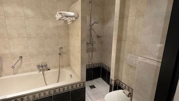 Une salle de bain avec une baignoire, une douche et des toilettes.