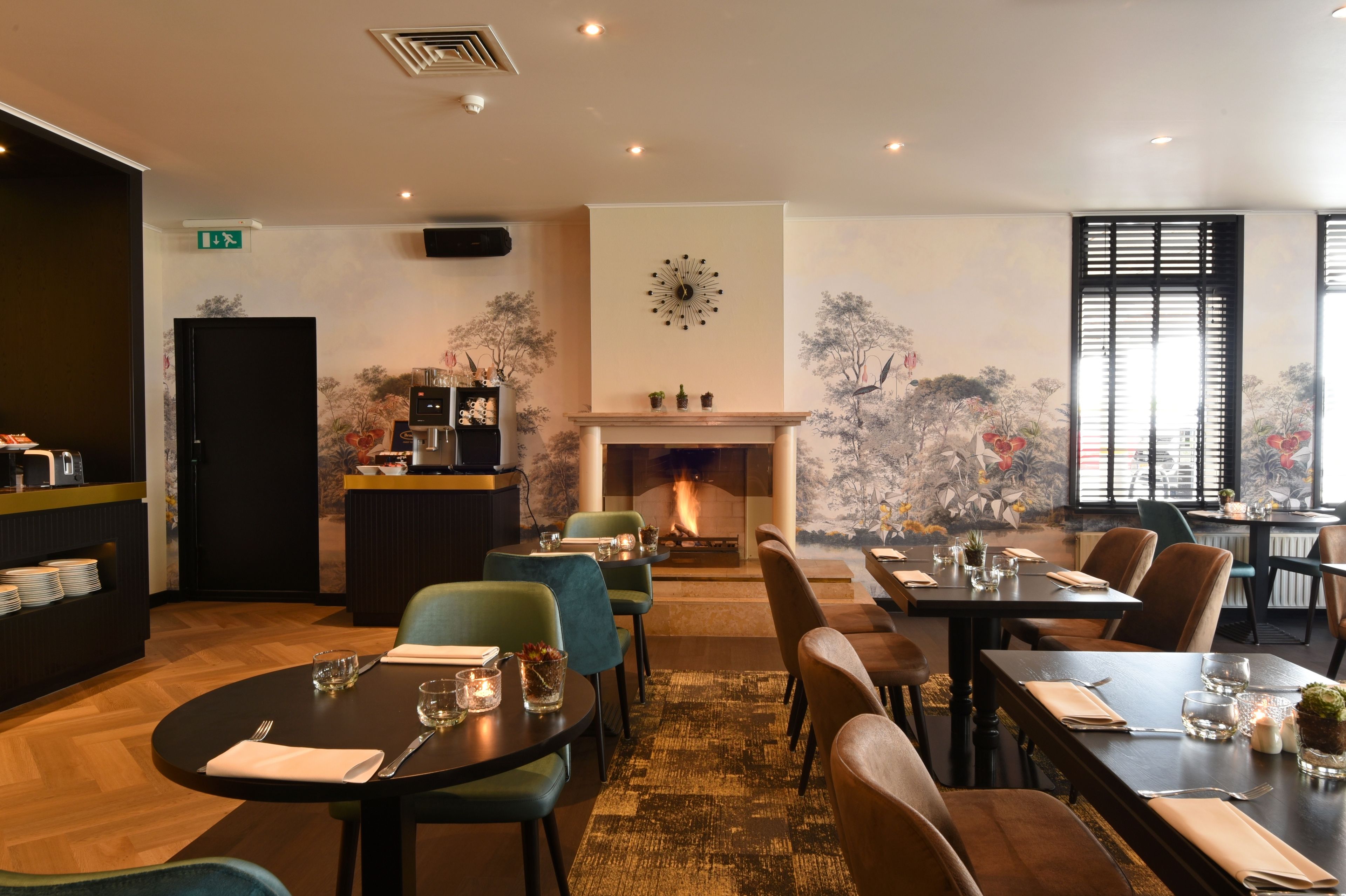 Un restaurante con chimenea, mesas de comedor, sillas y una pared con un reloj y obras de arte.