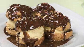 A plate of chocolate-covered ice cream cones with a glossy chocolate sauce.