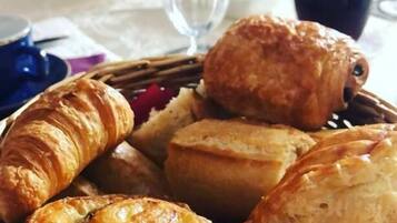 Un panier contenant un assortiment de viennoiseries, notamment des croissants et des pâtisseries feuilletées.