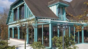 A large, two-story building with a prominent bay window and a covered porch area. - Hôtel Restaurant le Pan de Bois (Breviandes)