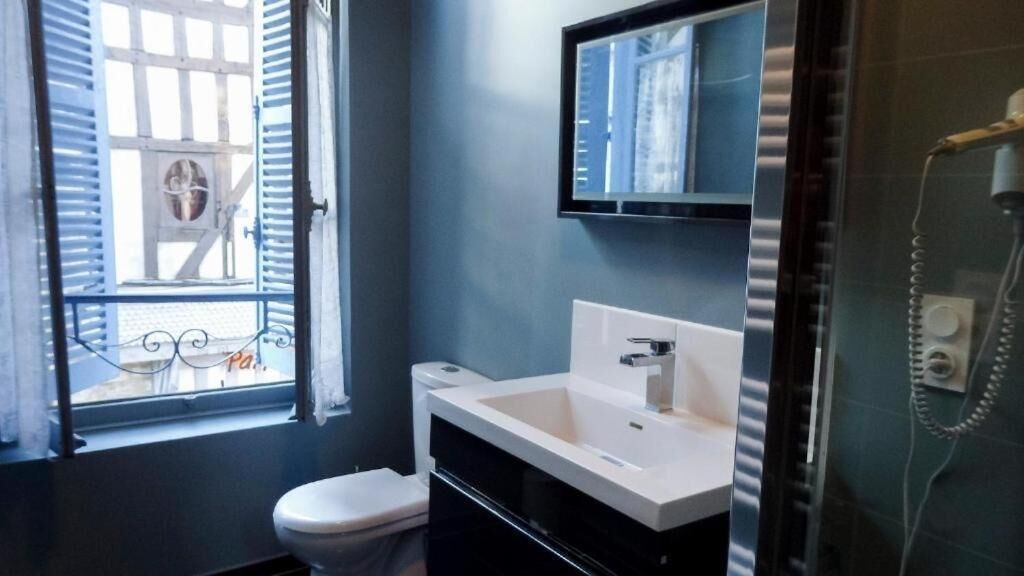 Une salle de bain avec un lavabo blanc, des toilettes et une douche.