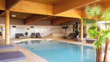 Een binnenzwembad en ligstoelen