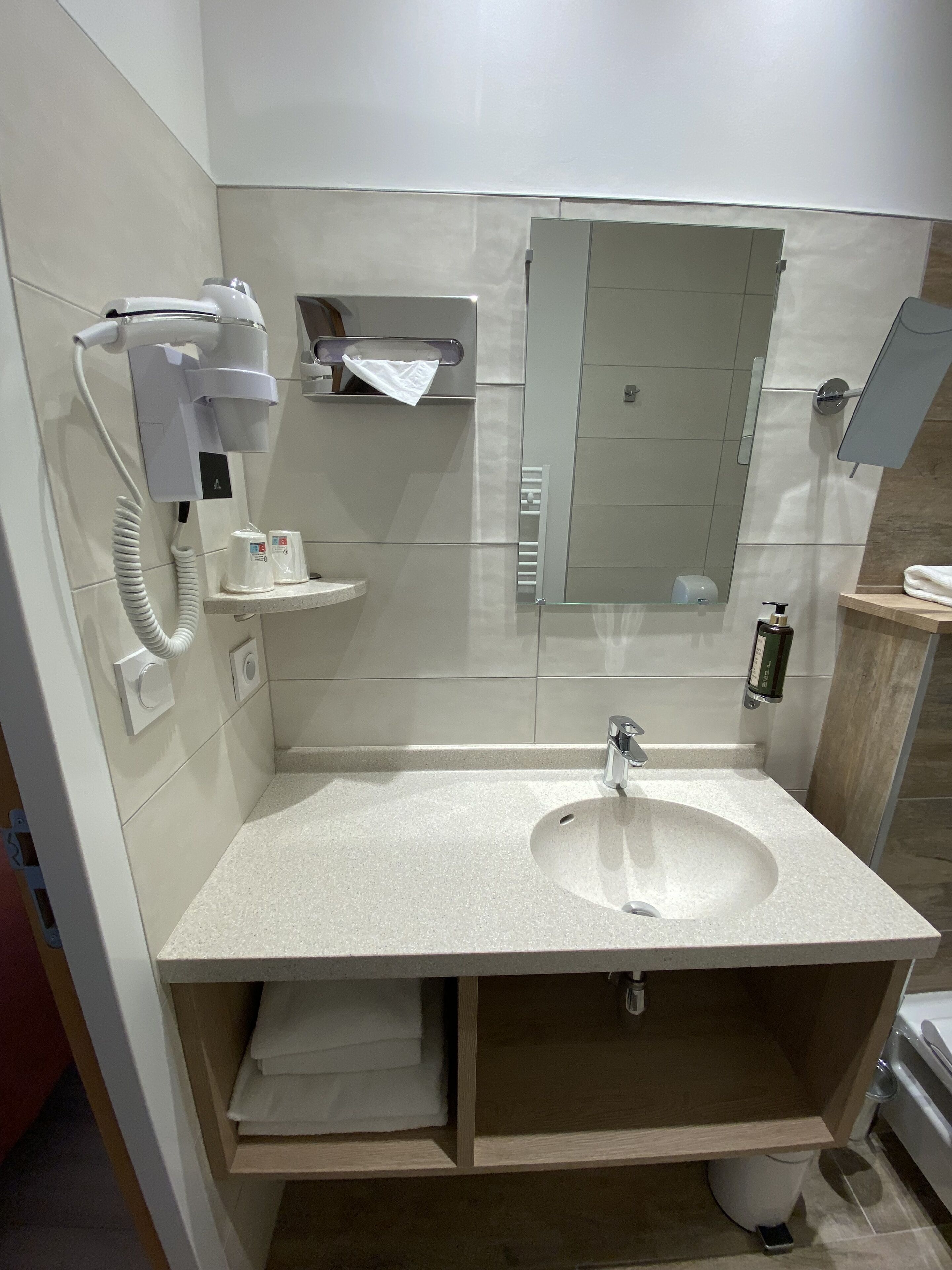 A modern bathroom with a sink, towel rack, and a mirror.