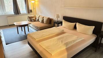Ein Hotelzimmer mit einem großen Bett, einer Couch, einem kleinen Tisch und einer Lampe.