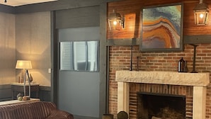 A modern living room with a fireplace, leather sofa, and a round coffee table. - The Seasons Lodge (Nashville)