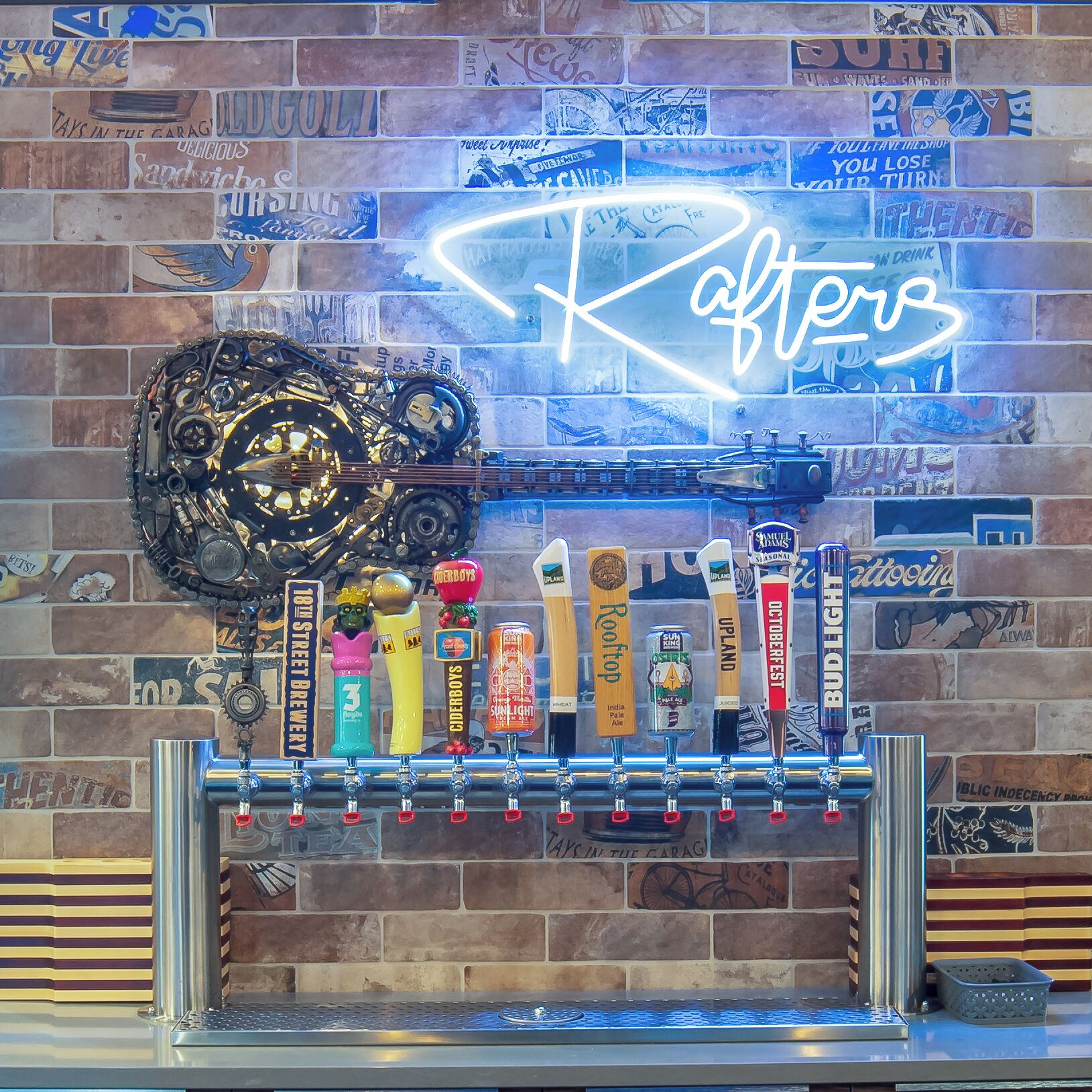 A bar with a neon sign reading "Rafter's" and a variety of beer taps.