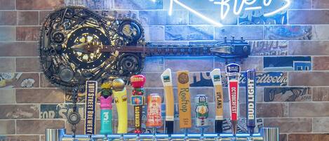 A bar with a neon sign reading "Rafter's" and a variety of beer taps.