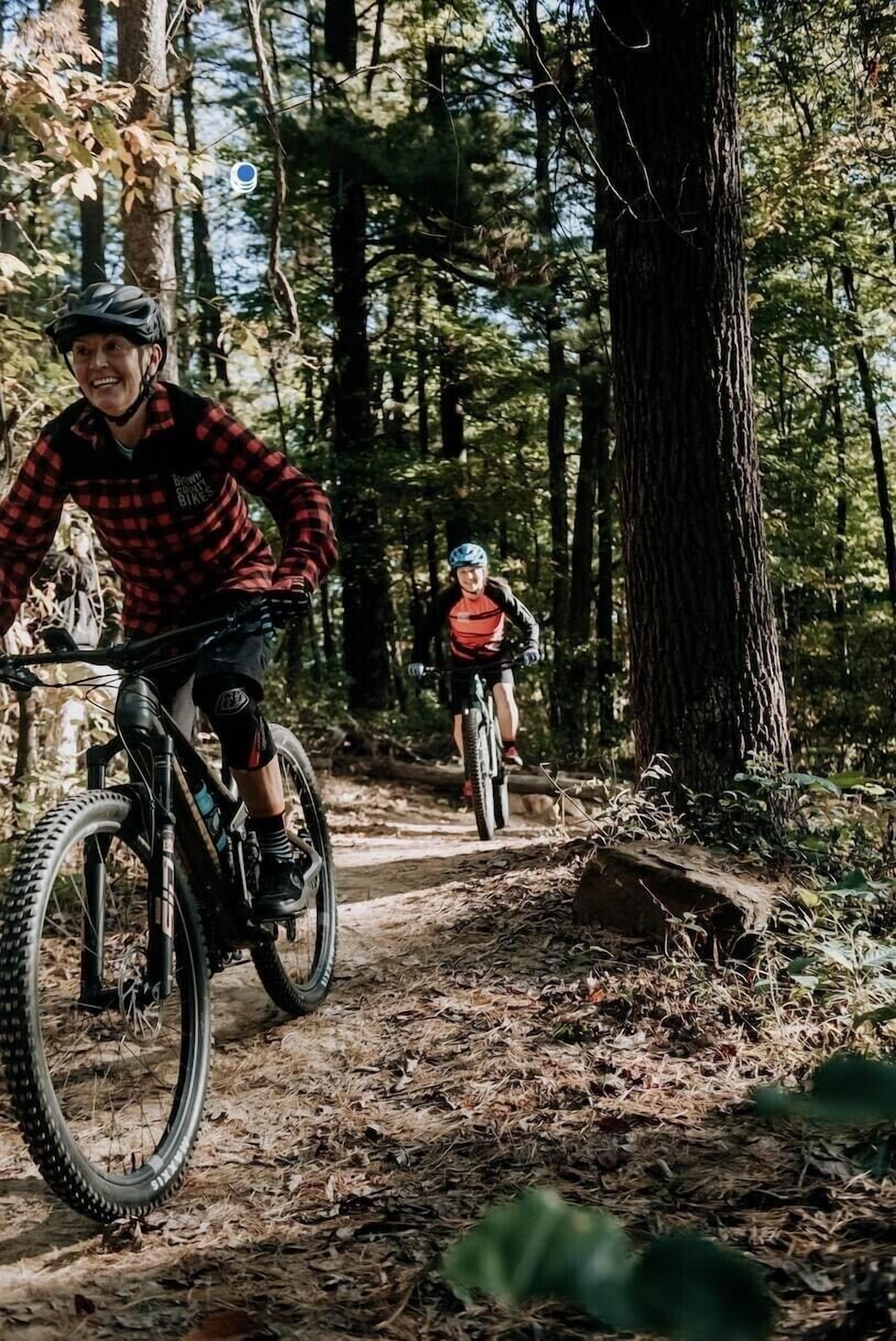 Two cyclists on a forest trail.
