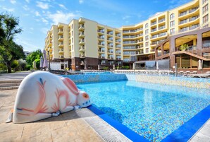 Una piscina al aire libre de temporada, sombrillas