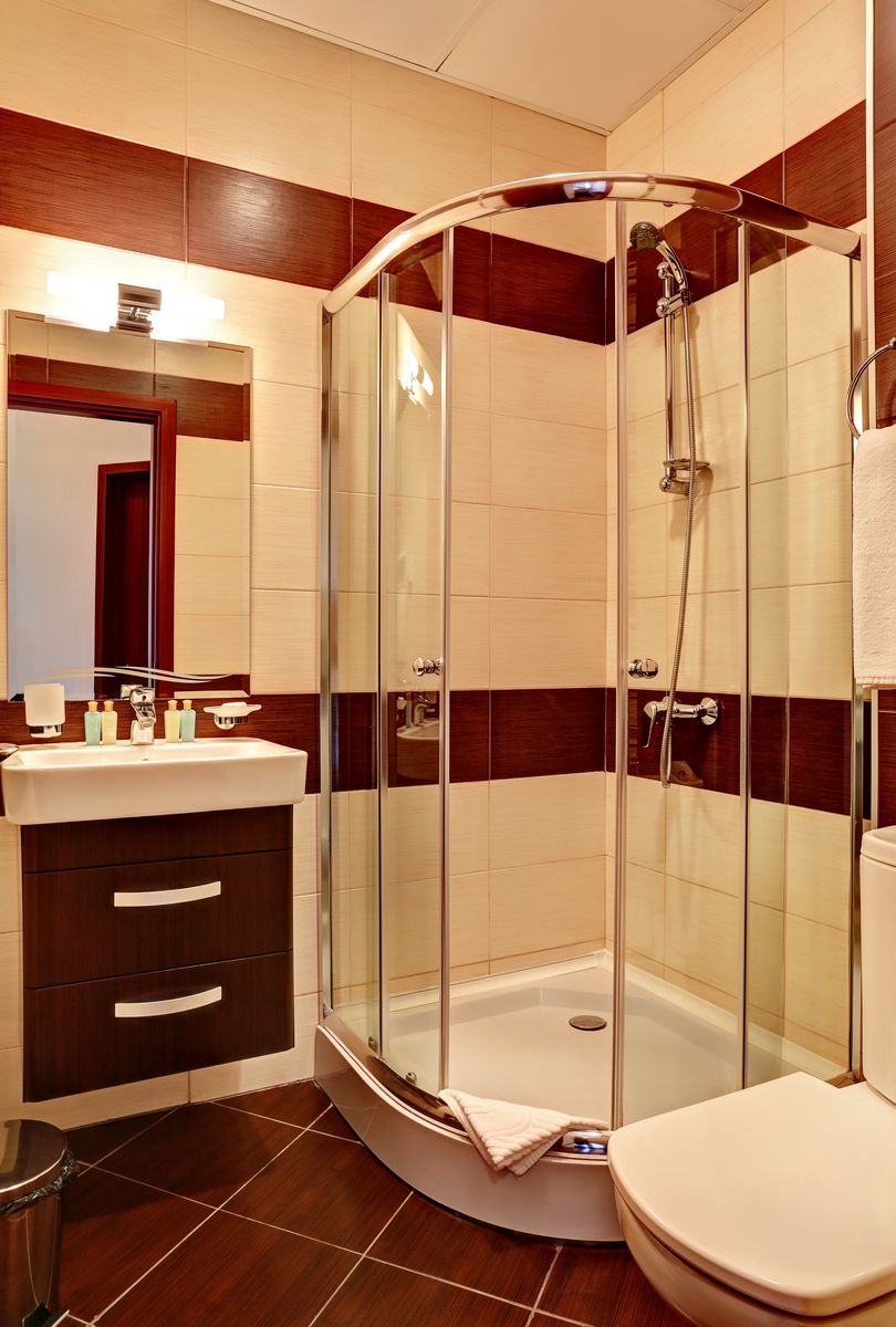 Une salle de bain moderne avec une douche à parois de verre, un meuble-lavabo avec un miroir et des toilettes.