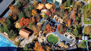 An aerial view of a park with a circular pond, stone pathways, and various trees. - Crowne Plaza Resort Changbaishan Hot Spring by IHG (Yanbian)
