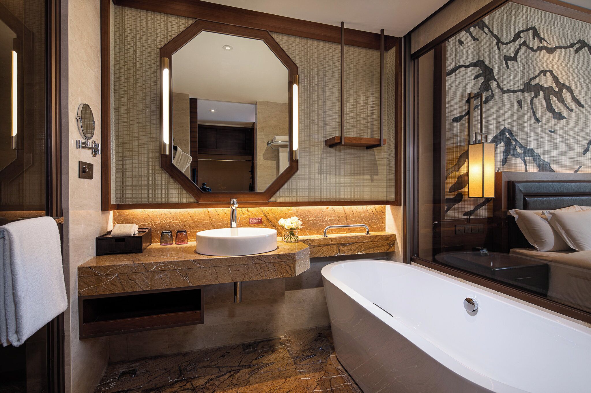 A modern bathroom with a freestanding bathtub, a large mirror, and a vanity with a sink and countertop.
