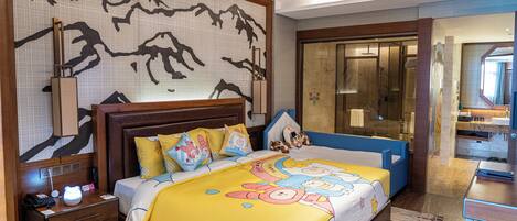 Habitación de hotel con cama, mesita de noche y un espejo grande.