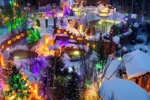 A snow-covered landscape with illuminated structures and pathways. - Crowne Plaza Resort Changbaishan Hot Spring by IHG (Yanbian)