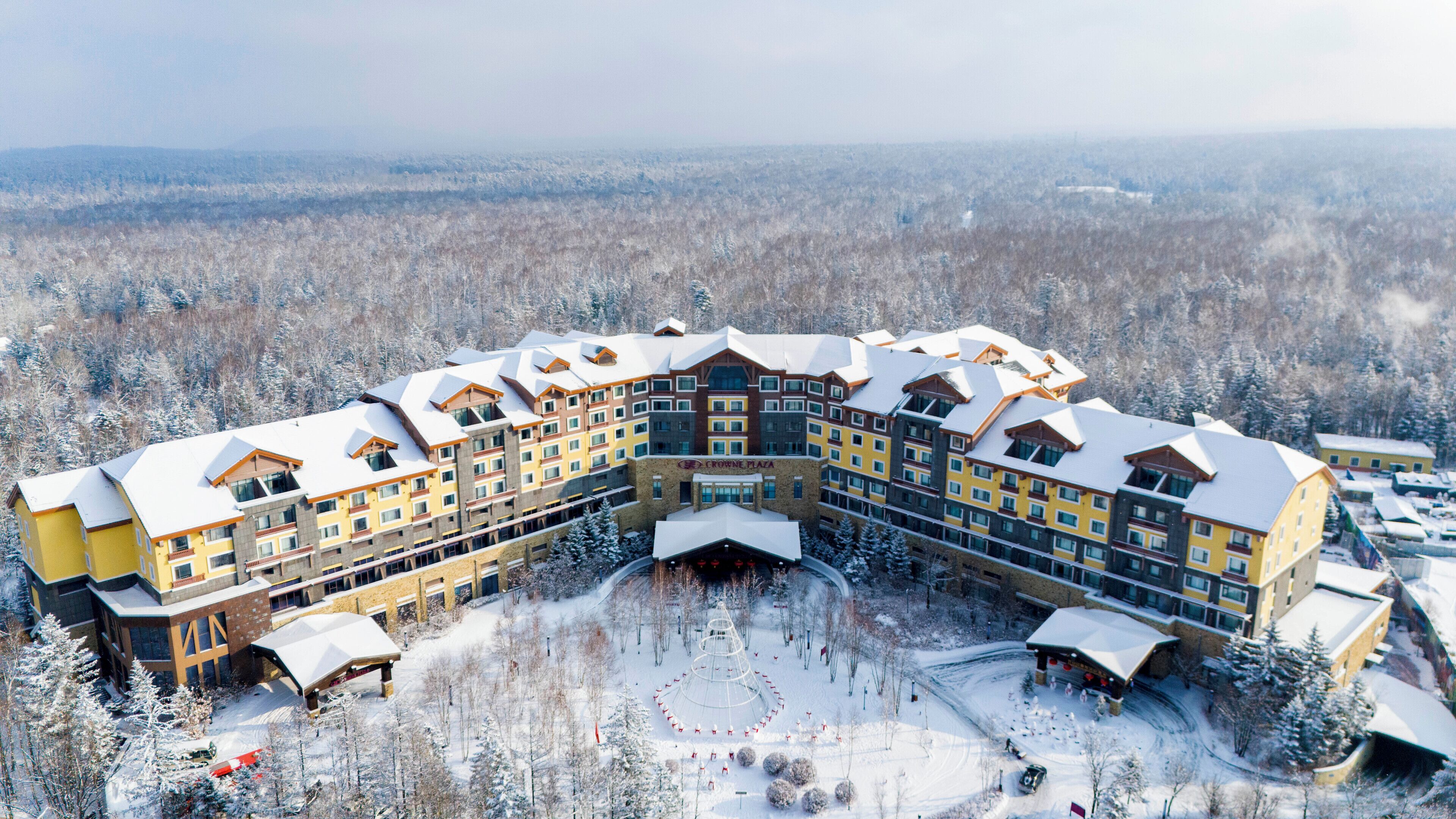 A large, multi-story hotel with a snow-covered roof and a central courtyard.