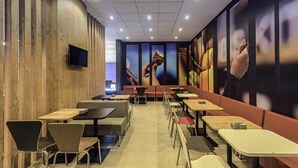 A restaurant interior with booths, tables, and chairs. - ibis Jacarei (Jacarei)