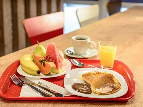 A breakfast tray with pancakes, fruit, a cup of coffee, and a glass of orange juice. - ibis Jacarei (Jacarei)
