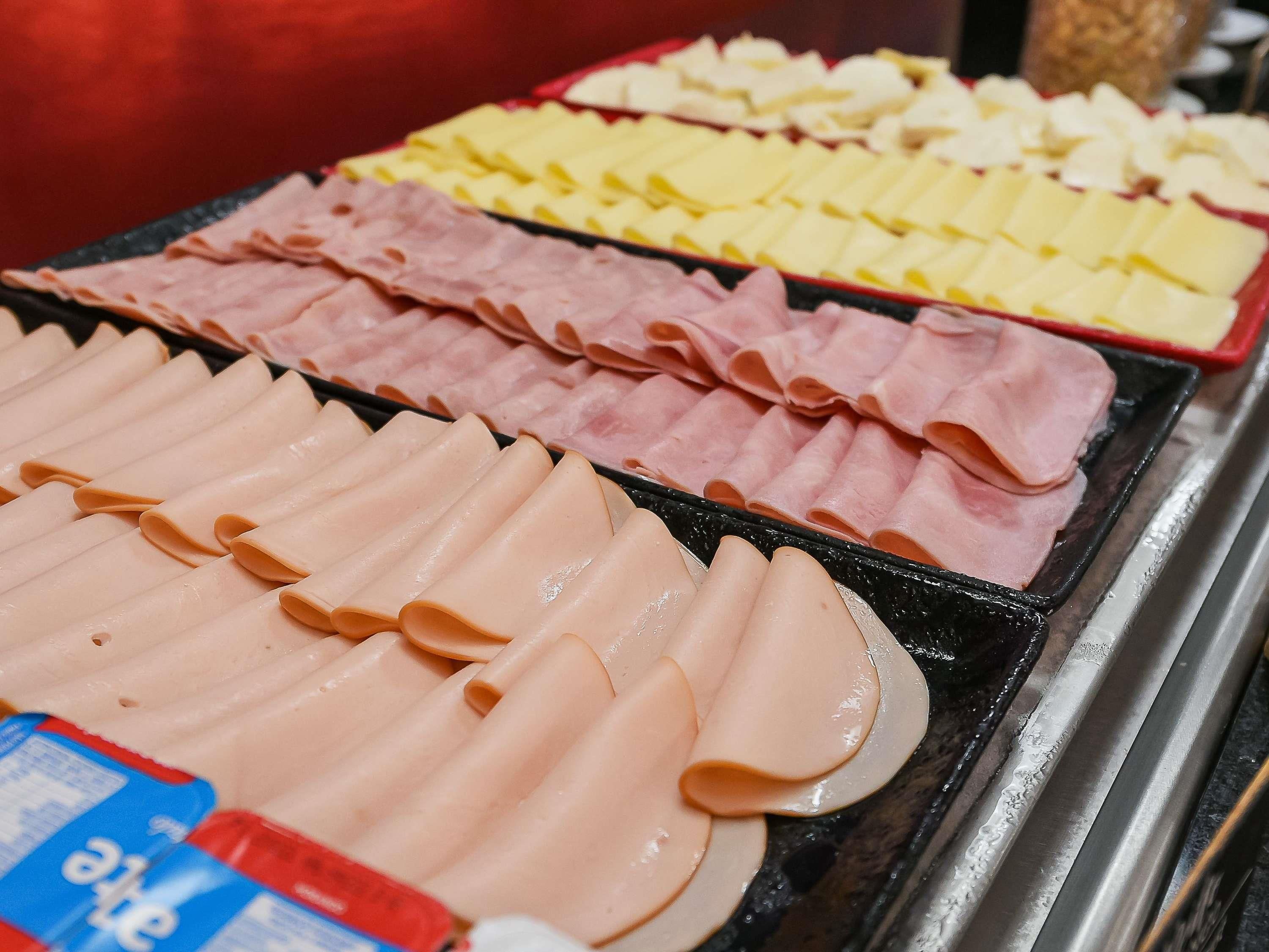 A buffet with various types of sliced meats.