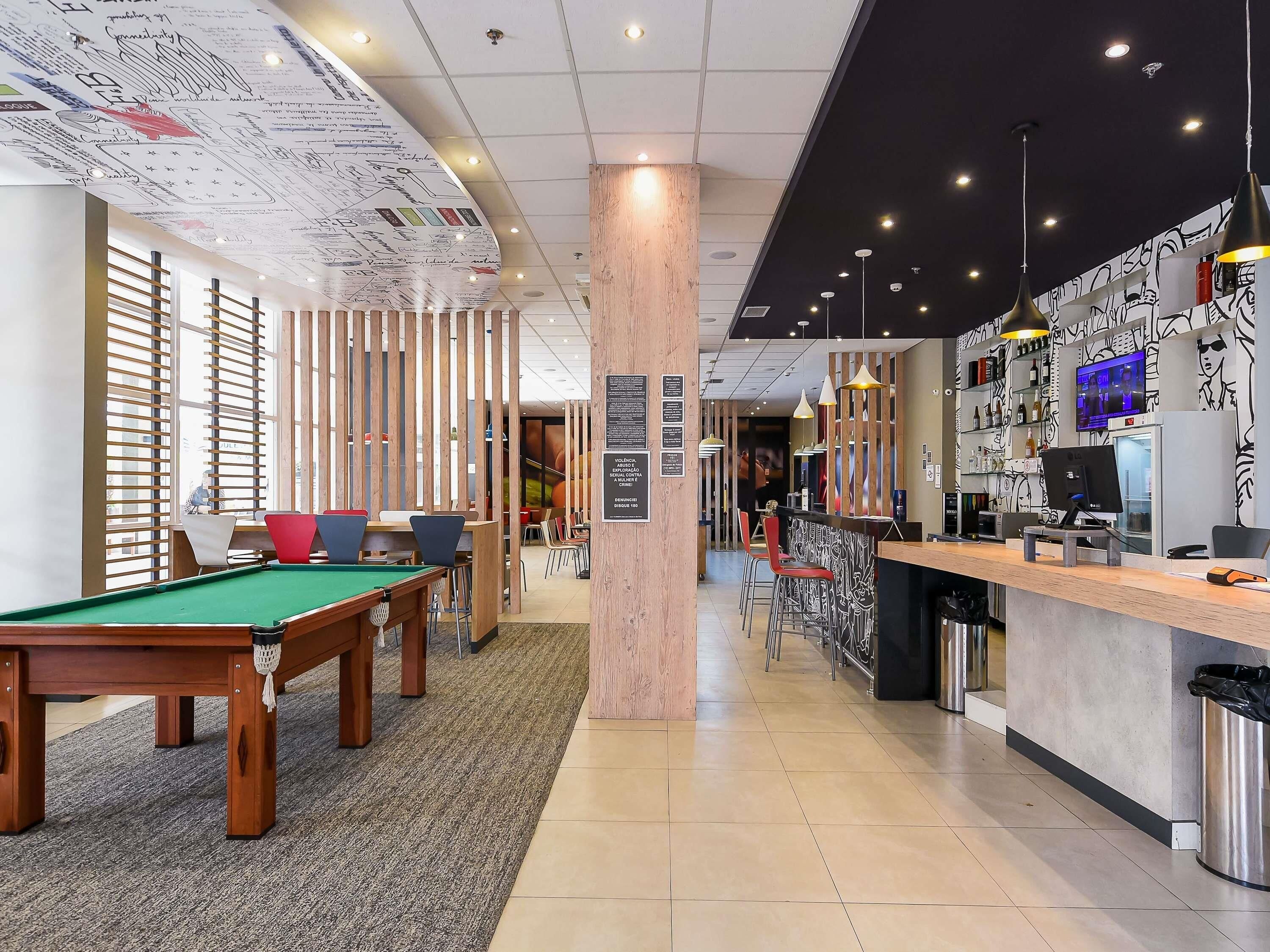 A billiards table, a bar area, and a seating area with a pool table.
