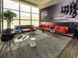 Un área de estar moderna con un sofá modular, una mesa de centro y un tablero de ajedrez.
