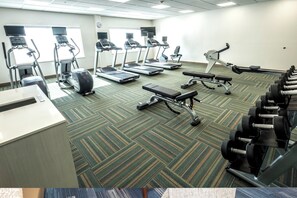 A fitness center with treadmills, ellipticals, and free weights.