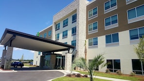 A multi-story hotel with a covered entrance, stone facade, and large windows. - Holiday Inn Express North Augusta by IHG (North Augusta)