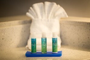 Three bottles of 'White Citrus' on a blue mat in a bathroom with a white towel in the background. - Holiday Inn Express North Augusta by IHG (North Augusta)