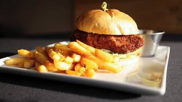 Un plato con una hamburguesa de pollo y papas fritas.