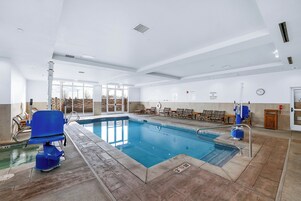 Una piscina techada, sillones reclinables de piscina