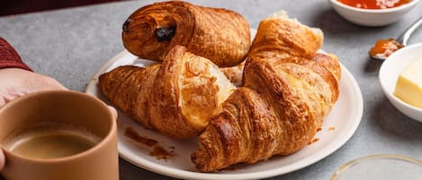 A plate with croissants and a cup of coffee.