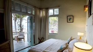 A bedroom with a bed, a chair, a lamp, and a view of the outdoors. - La Casa los Tumpis (Zorritos)