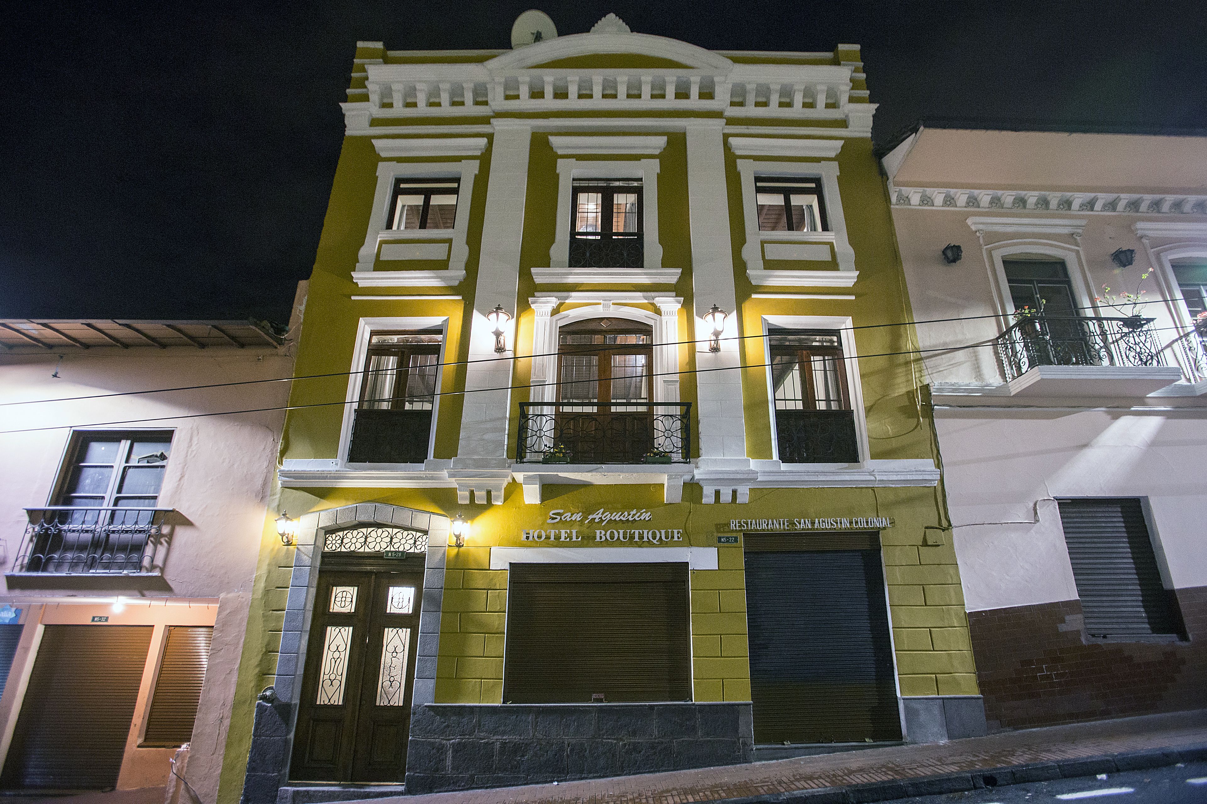Un hotel con fachada clásica, que presenta una entrada destacada con un arco decorativo y un letrero que dice "San Agustin Hotel Boutique".